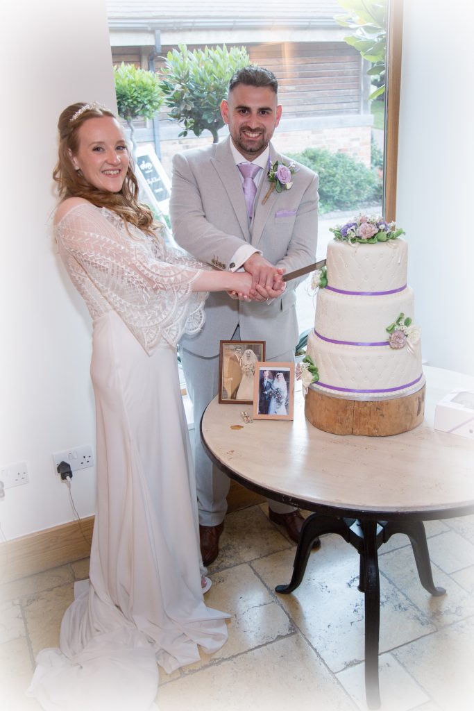 A bride and groom cutting their wedding cake