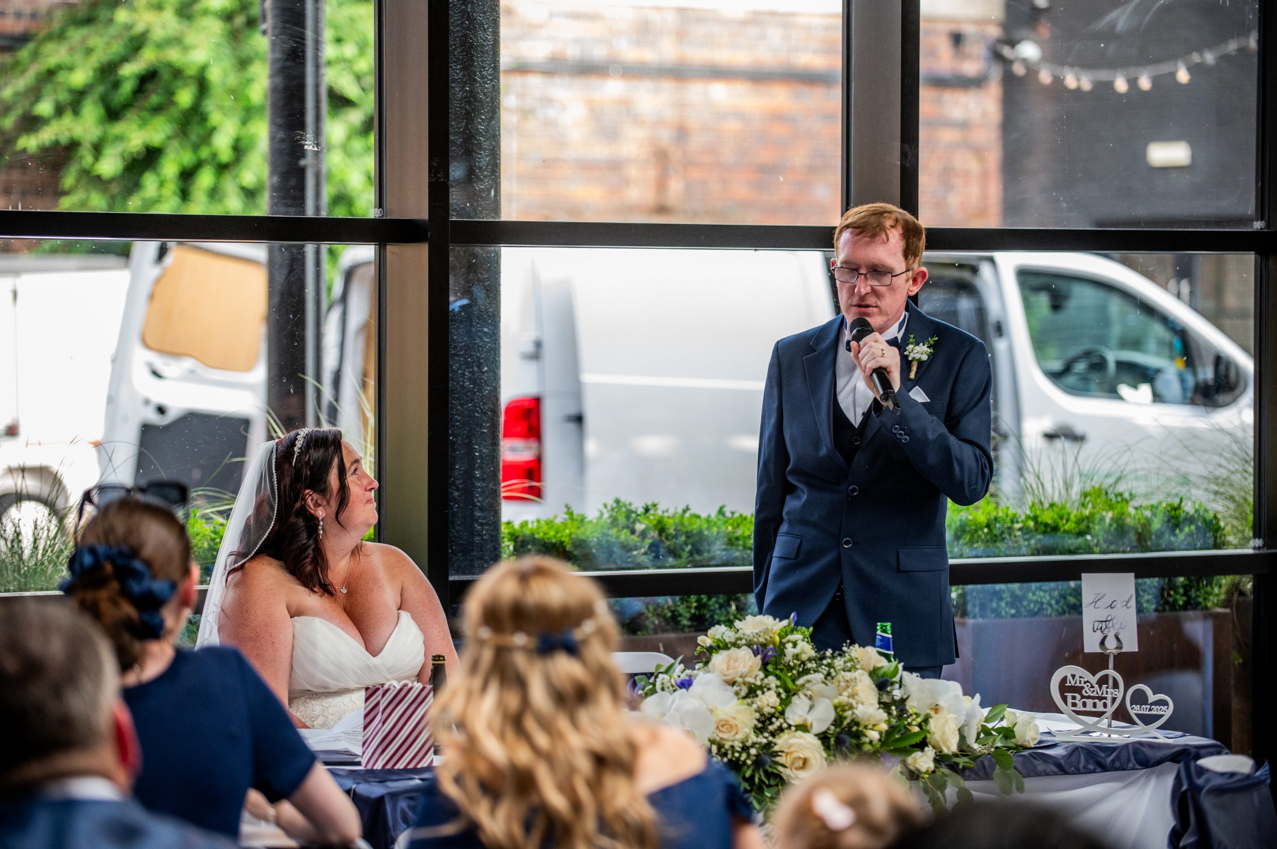 Bride and groom with groom giving a speech