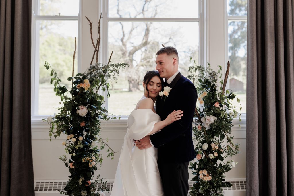 bride and groom wedding ceremony surrounded by fresh flower arch