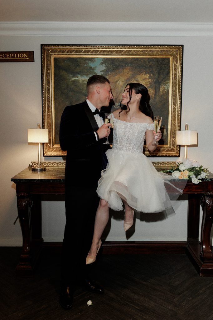 bride and groom in front of a painting