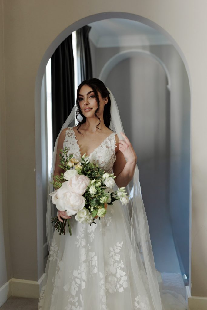 bride holding fresh flower bouquet with peonies