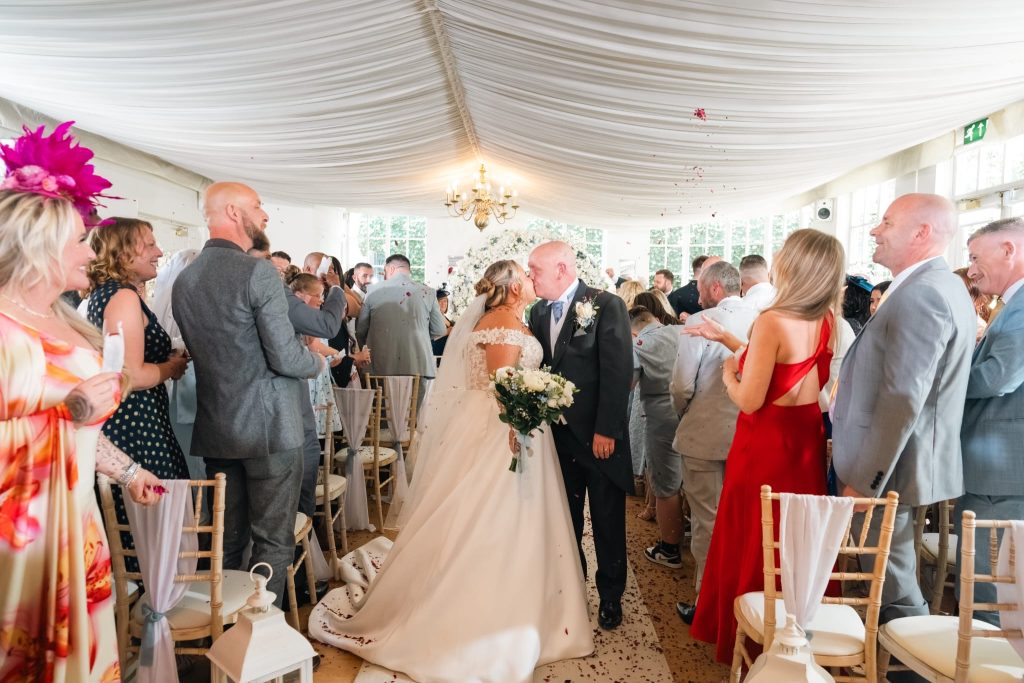 bride and groom kissing in aisle